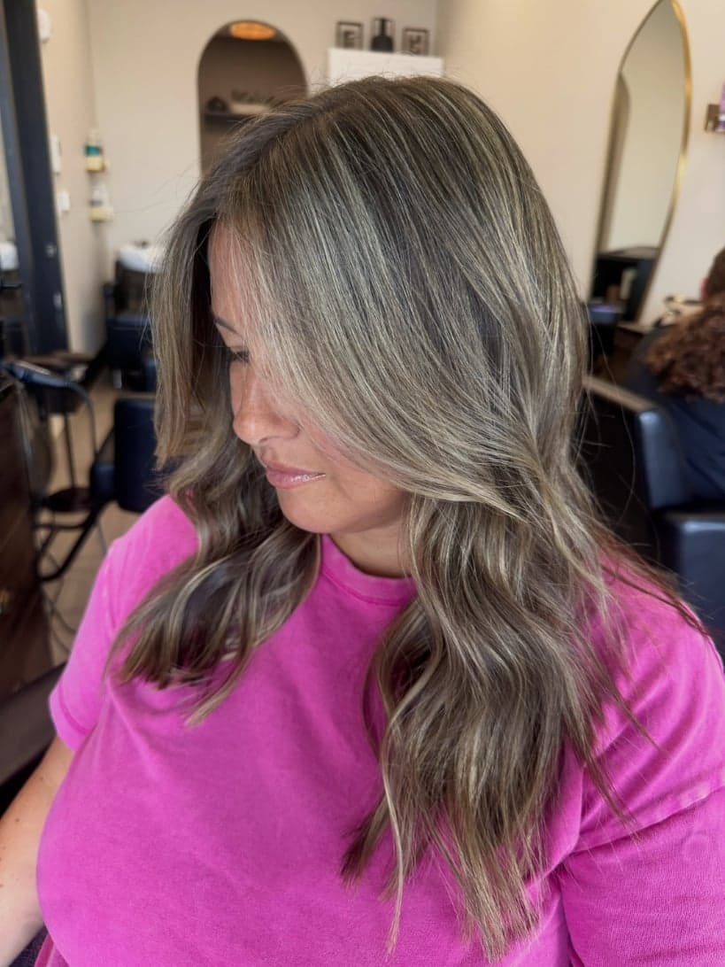 Cool beige-blonde babylights brightening a brunette base, side view — hair by Alchemy Loft