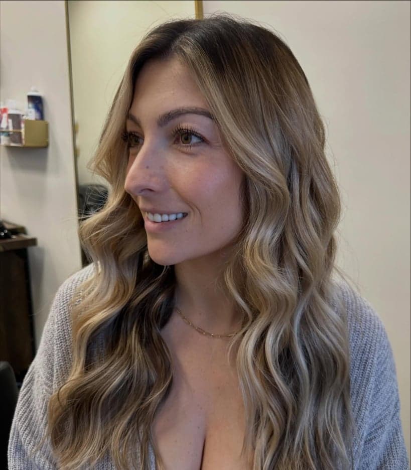 Transformation to a beige blonde with a deep root shadow and bright face-framing pieces, long waves — hair by Alchemy Loft