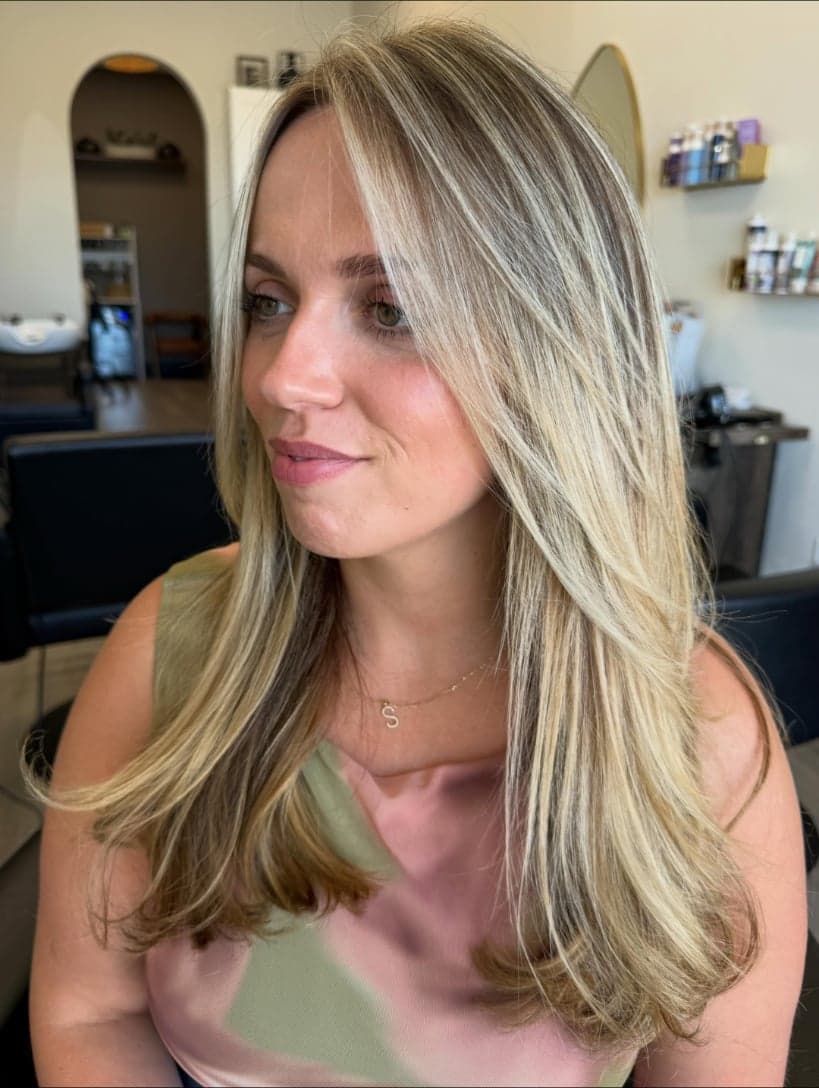 Long hair with soft face-framing layers and bright blonde pieces at the front — hair by Alchemy Loft