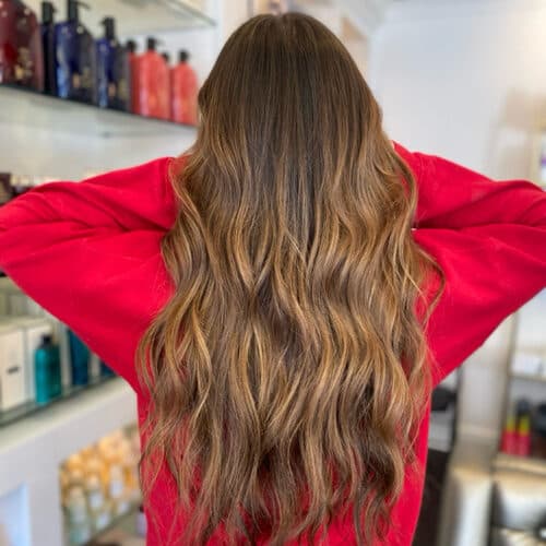Long caramel balayage, back view — hair by Alchemy Loft